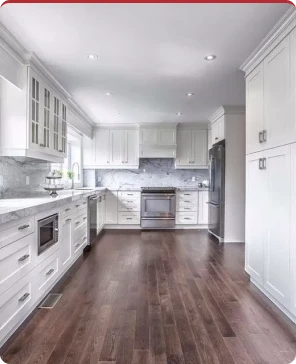Renovated kitchen with white cabinetry and dark wood flooring