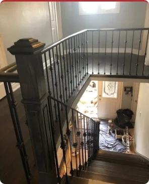 Staircase with wrought iron railing overlooking entryway