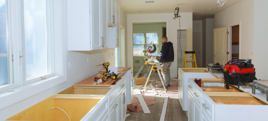 Carpenter using a miter saw inside a home during a kitchen renovation Toronto project.