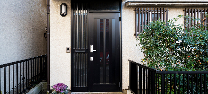 Modern black exterior front door with vertical glass inserts and matching sidelight installed on a Mississauga residential entryway.